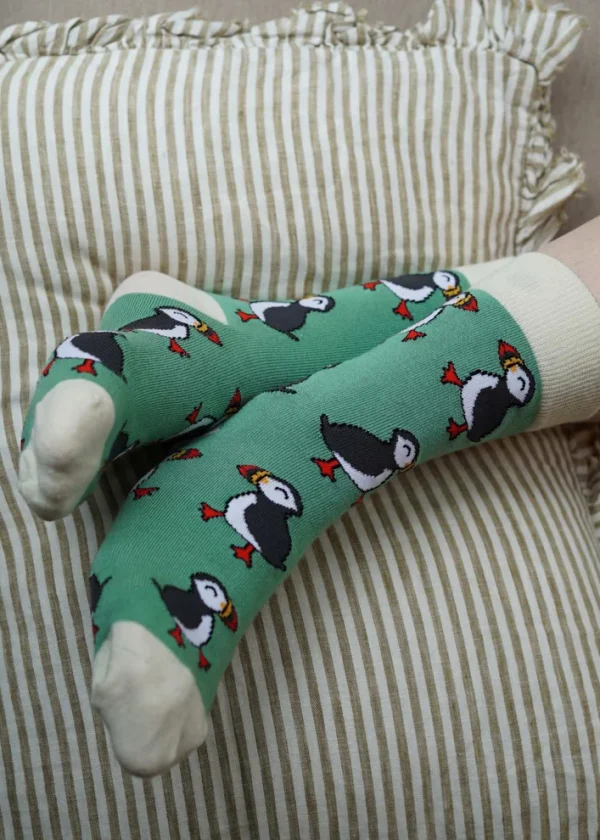 Bare Kind Save the Puffins green bamboo socks on a person's feet