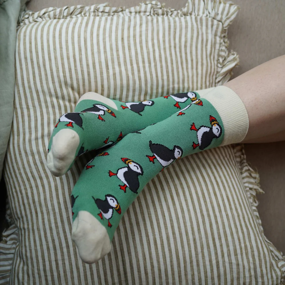 Bare Kind Save the Puffins green bamboo socks on a person's feet